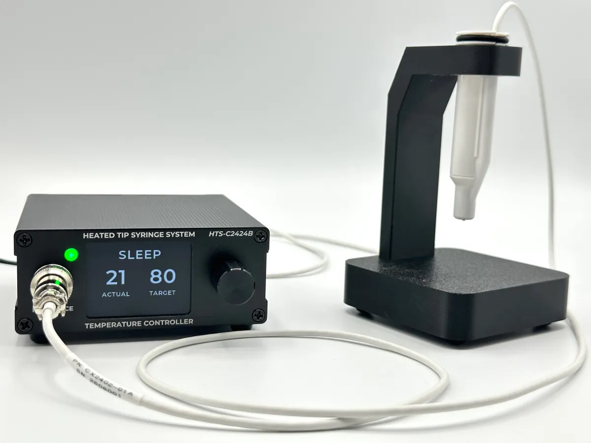 Croxel HTS Heated Tip Syringe System powered on, with controller display active and handpiece resting in the smart holder
